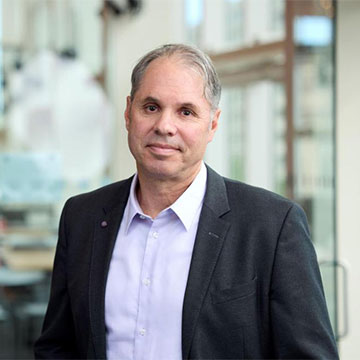 Headshot of David Bogen with a cafe in the background