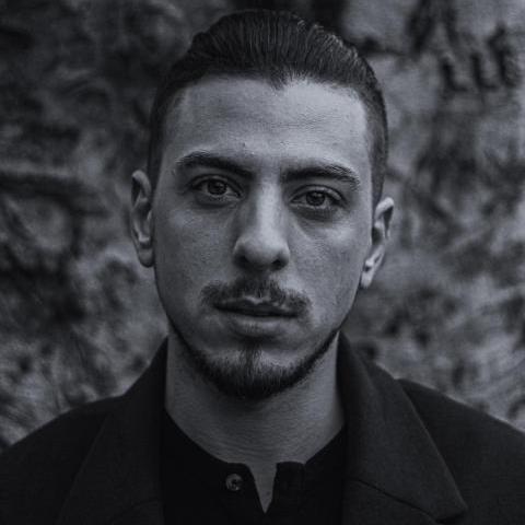 Black & white photo of Martin Guas looking directly at the camera with a serious expression