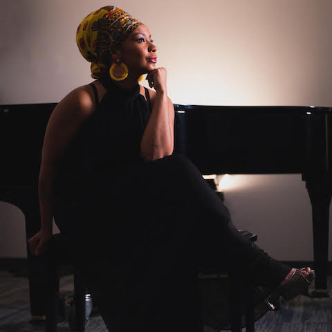 Zahili Gonzalez Zamora sitting & thinking in front of a grand piano