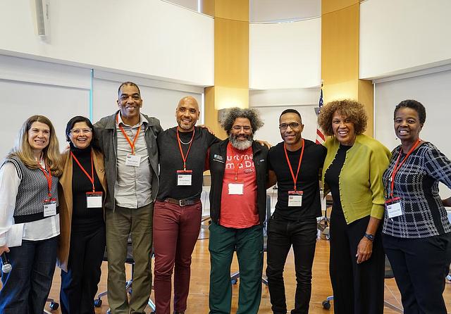 A group of people standing together smiling. 
