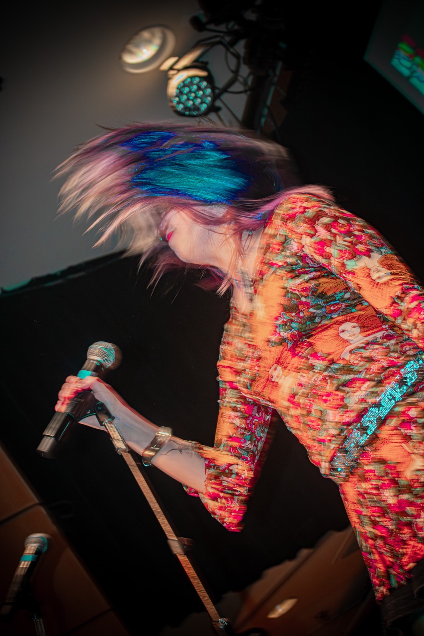 Opal Gibbons performing with a mic