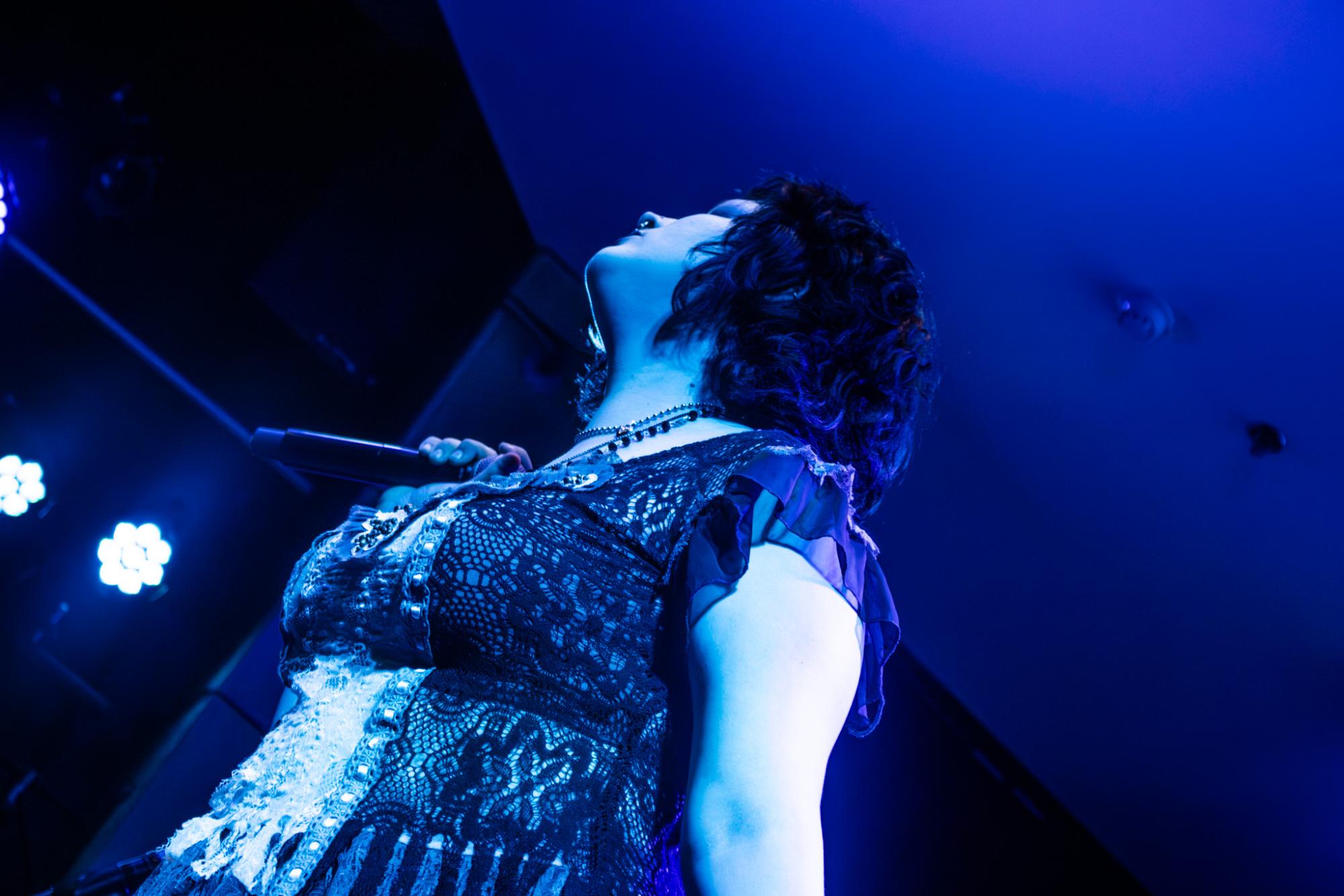 Juno Meyers is caught in a wash of blue light during the masterclass, another intentional motion shot.