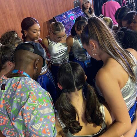 Assistant Professor of Dance Ruka Hatua-Saar White (left) and student dancers share a moment, pre-performance.