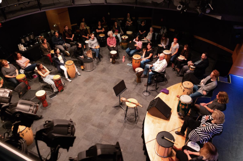 A group of people playing instruments in a circle.