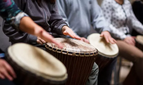 A photo of people playing percussion instruments. 