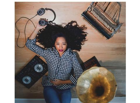 Angelika Beeker lying down against a wooden floor and sound equipment